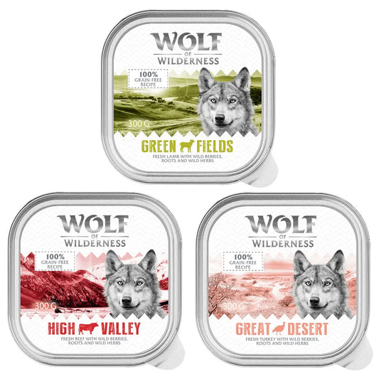 Three containers of Wolf of Wilderness pet food with different labels on a white background